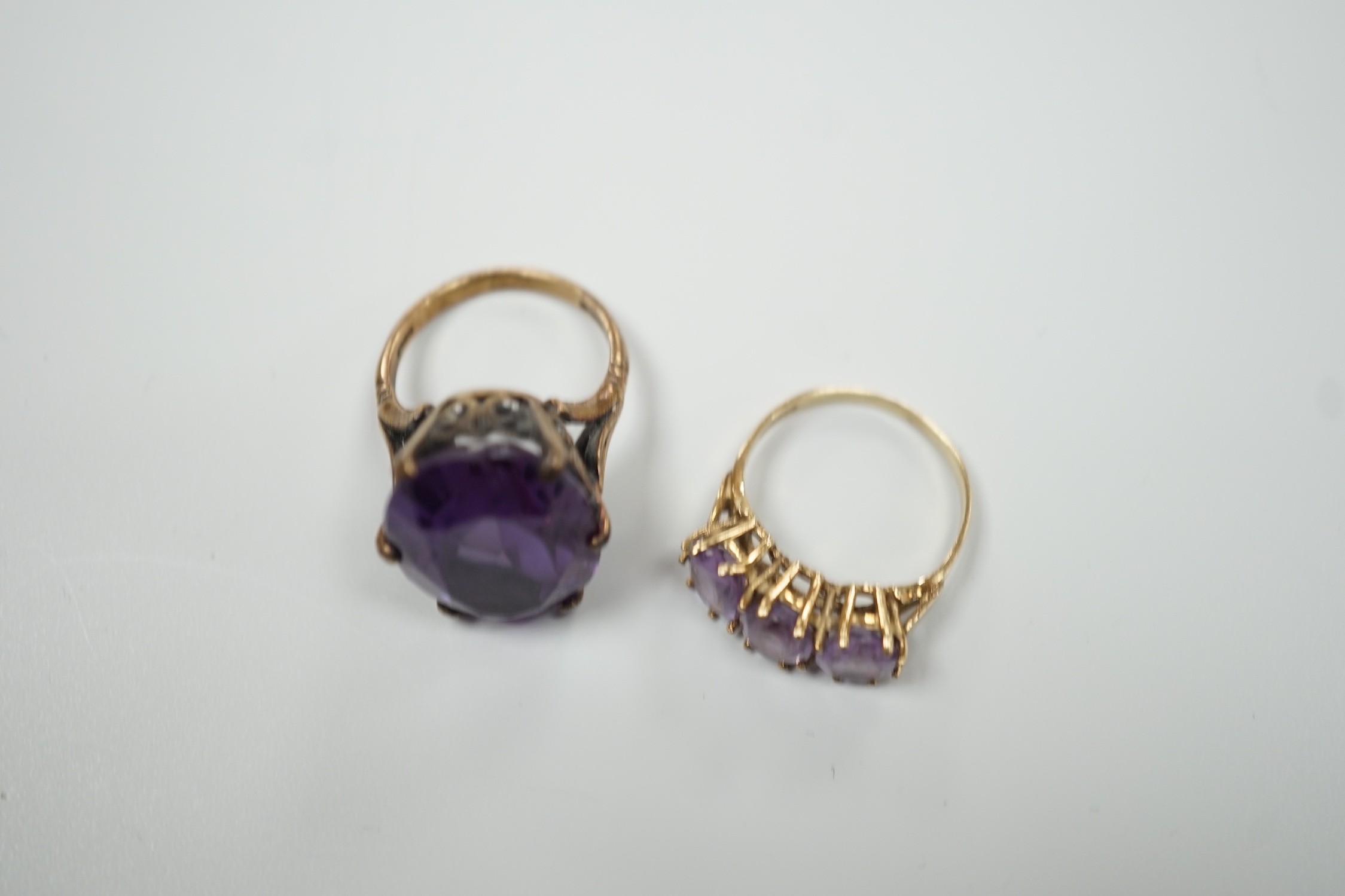 A modern 9ct gold and three stone amethyst set half hoop ring and a 9ct gold and synthetic colour change corundum set dress ring, gross weight 12.4 grams.